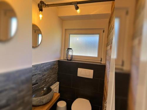 ein Badezimmer mit Waschbecken und Toilette und einem Fenster in der Unterkunft Black Forest Appartement - Brandenkopfblick in Zell am Harmersbach
