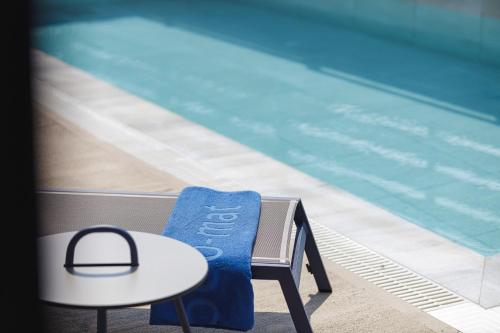 a blue chair next to a swimming pool at Iron Villas - Nefeli & Oniros in Pangalochori