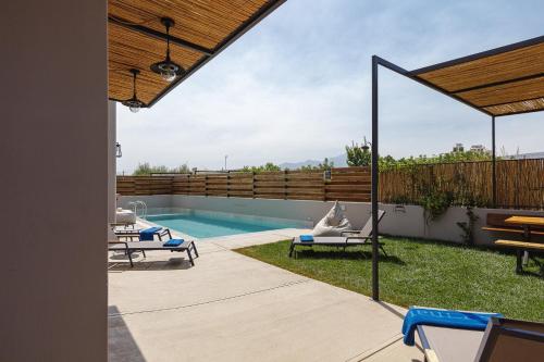 a backyard with a swimming pool and a wooden fence at Iron Villas - Nefeli & Oniros in Pangalochori