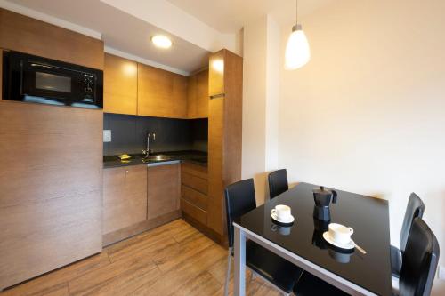 a small kitchen and dining room with a table and chairs at Apartaments Trainera in Esterri d'Àneu