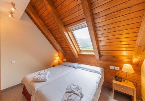 a bedroom with a bed in a room with a window at Apartaments Trainera in Esterri d'Àneu