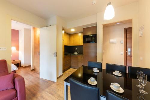 a kitchen and a living room with a table and chairs at Apartaments Trainera in Esterri d'Àneu