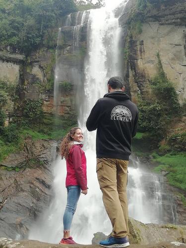 a man and a girl standing in front of a waterfall at AGP home in Nuwara Eliya