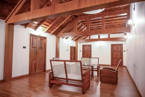 a room with a table and chairs and wooden ceilings at Surya Heritage Hotels in Kannur