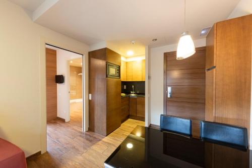 a living room with a table and a kitchen at Apartaments Trainera in Esterri d'Àneu