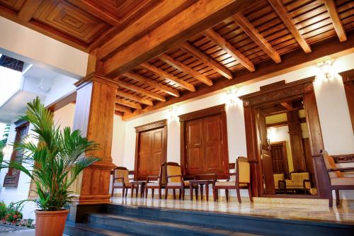 a room with a table and chairs in a building at Surya Heritage Hotels in Kannur