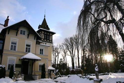 a house with a clock tower in the snow at Glögglhof in Trofaiach