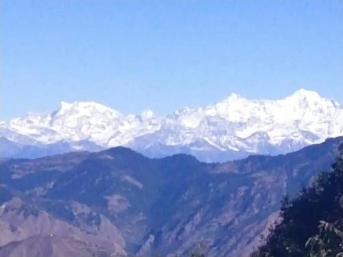 a mountain range with snow capped mountains in the distance at Dhanaulti Camp Homes Retreat in Dhanaulti