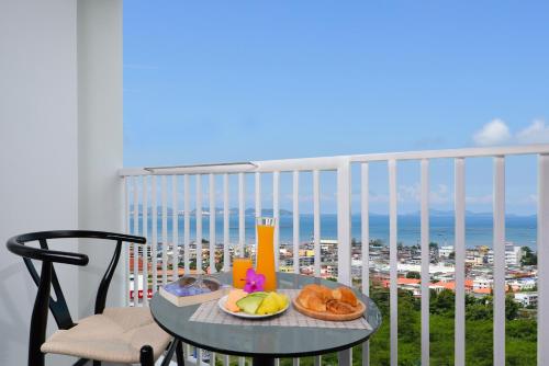 a table with fruit on a balcony with a view of the ocean at Centre Point Prime Hotel Pattaya in Pattaya North
