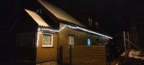 a house with lights on the side of it at night at Beskidzki Klimat Jaśliska in Jaśliska