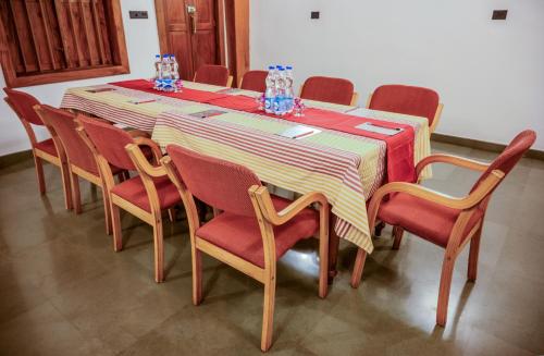 a table with chairs and a red and yellow striped table cloth at Surya Heritage Hotels in Kannur