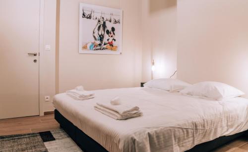 - une chambre avec un grand lit blanc et des serviettes dans l'établissement Appartementen by WP Hotels, à Blankenberge