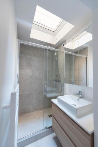 une salle de bain avec une douche en verre et un lavabo dans l'établissement Stockholm, à Paris