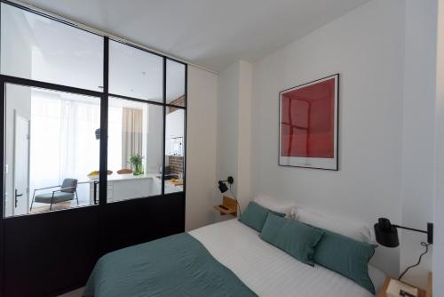 une chambre avec un lit et une grande fenêtre dans l'établissement Stockholm, à Paris