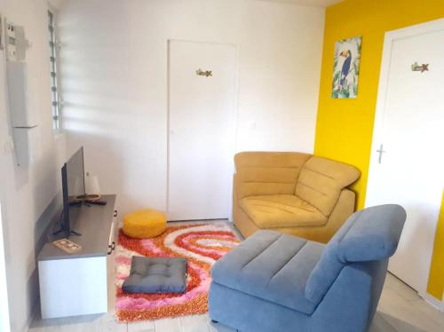a living room with a couch and a chair at Maison charmante à Morne-à-l'Eau avec jardin clôturé in Morne-à-lʼEau