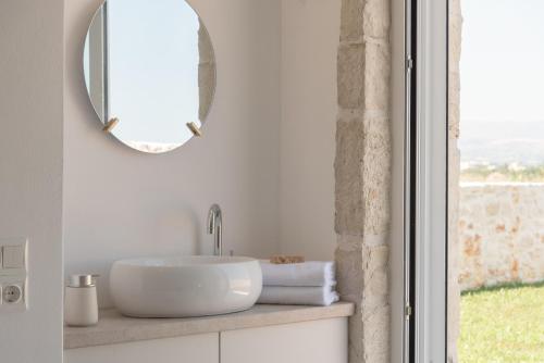 a white bathroom with a sink and a mirror at Evaero Villas I, II, III, IV, Family Retreats, By ThinkVilla in Sfakaki