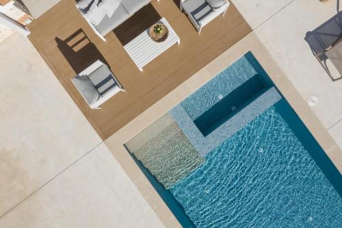 an overhead view of a swimming pool in a house at Evaero Villas I, II, III, IV, Family Retreats, By ThinkVilla in Sfakaki