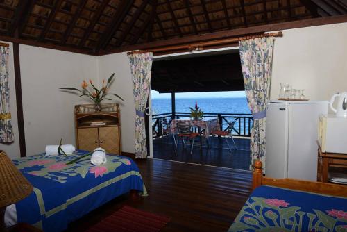 a bedroom with a bed and a view of the ocean at Pension de famille HITI MOANA VILLA in Papara