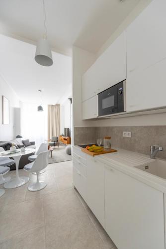 une cuisine avec des armoires blanches et un salon dans l'établissement Denver, à Paris