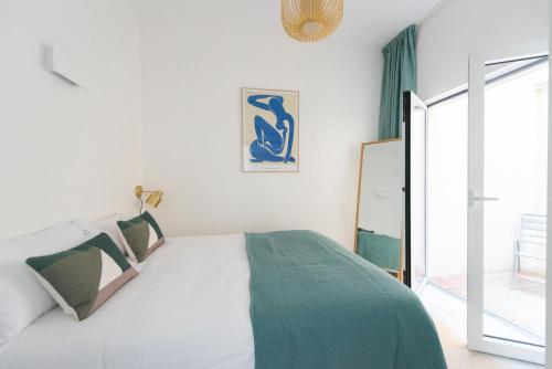 - une chambre avec un lit blanc et une couverture verte dans l'établissement Denver, à Paris