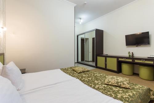 a hotel room with a bed and a tv at Hotel Voyage in Kharkiv