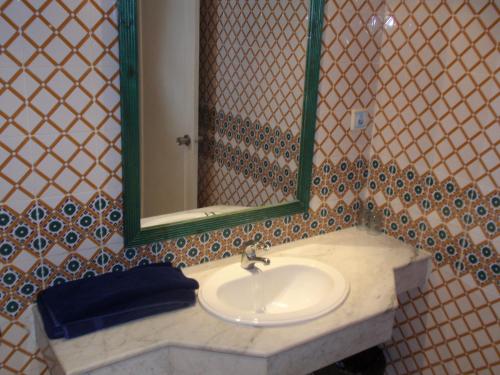 a bathroom with a sink and a mirror at Hotel Mezri in Monastir