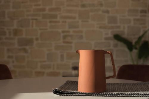 a orange jug sitting on a table in a room at Evaero Villas I, II, III, IV, Family Retreats, By ThinkVilla in Sfakaki