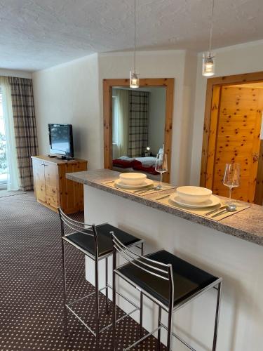a kitchen with a bar with two chairs and a counter at W5 Haus Ganghofer in Leutasch