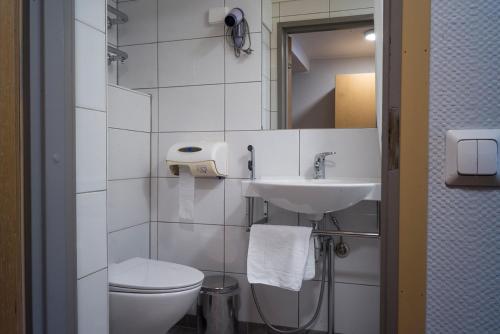 Baño blanco con aseo y lavamanos en Forenom Aparthotel Kemi en Kemi