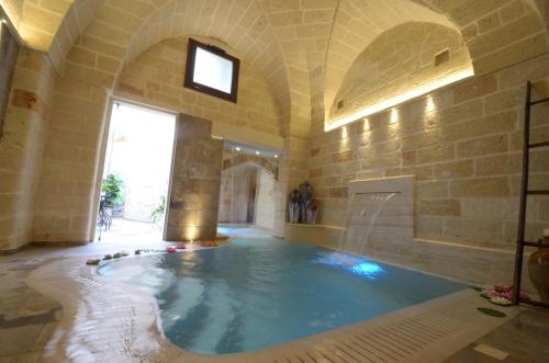 een groot binnenzwembad in een gebouw met een bad bij B&B Corte Dei Figuli in San Pietro in Lama
