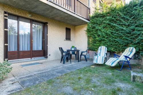 a patio with a table and chairs in front of a house at Le Chanchore - appartement 2 chambres avec jardin proche Embrun in Saint-Sauveur