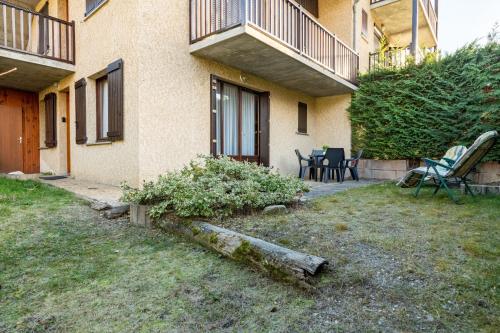 a house with a yard with chairs and a table at Le Chanchore - appartement 2 chambres avec jardin proche Embrun in Saint-Sauveur