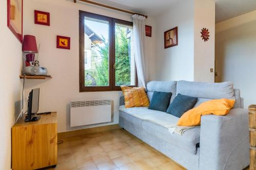 a living room with a blue couch and a window at Le Chanchore - appartement 2 chambres avec jardin proche Embrun in Saint-Sauveur