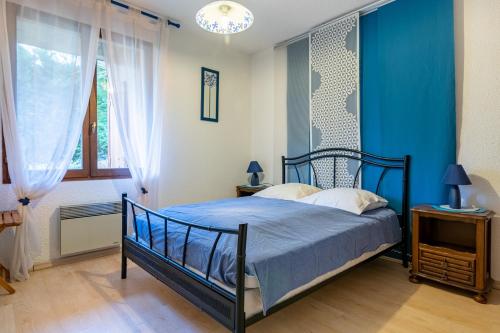 a bedroom with a bed and a blue wall at Le Chanchore - appartement 2 chambres avec jardin proche Embrun in Saint-Sauveur