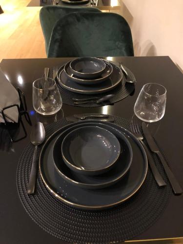 a table with black plates and utensils on a table at ELICAL Exclusive Private Suites in Rome