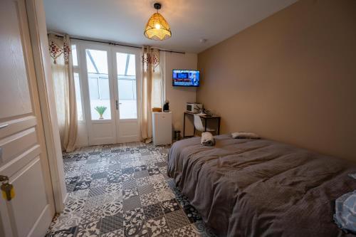 a bedroom with a bed and a tv and a window at NG SuiteHome - Lanester Lorient - Balnéo - Netflix - Wifi in Lanester