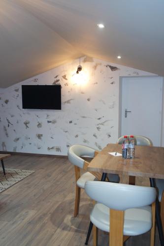 a dining room with a table and chairs and a tv at Logement de La Sittelle in Aizenay