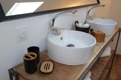 uma casa de banho com um lavatório branco e um espelho. em Logement de La Sittelle em Aizenay