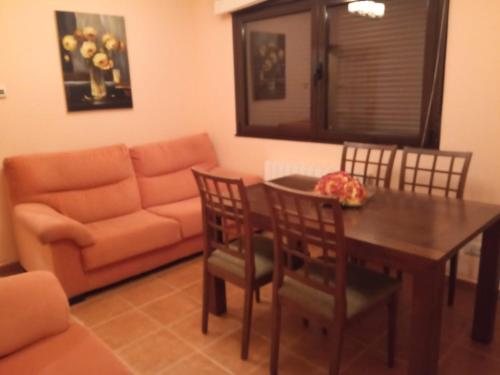 sala de estar con mesa, sillas y sofá en Casa Rural Blascosancho, en Blascosancho