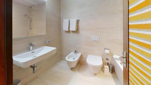 uma casa de banho branca com um lavatório e um WC em St Moritzerhof 62 em St. Moritz