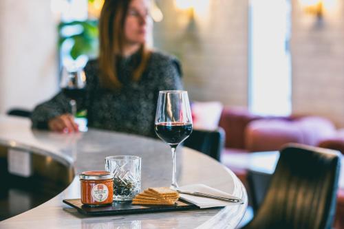 a table with a glass of wine and crackers on it at The ReMIX Hotel in Paris