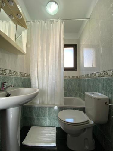 a bathroom with a toilet and a sink and a tub at Los Zifios in La Restinga