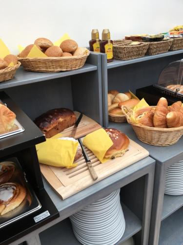 a shelf filled with different types of bread and pastries at Hotel Oude Abdij in Lo-Reninge
