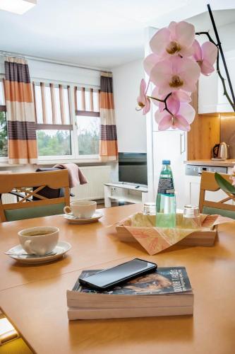 un tavolo con un libro e dei fiori sopra di Jägerhaus Donaueschingen a Donaueschingen