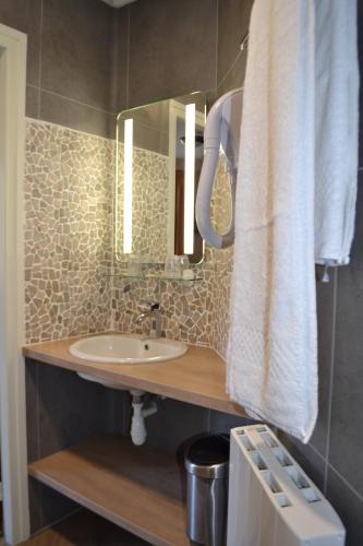 a bathroom with a sink and a mirror at AUBERGE d'ARANC in Aranc