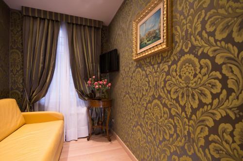 a living room with a couch and a painting on a wall at Ca' Marinella in Venice