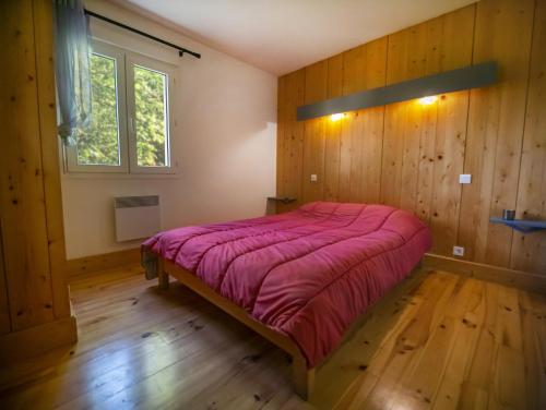 a bedroom with a bed in a room with wooden walls at Village de Gites le Colombier in Mende