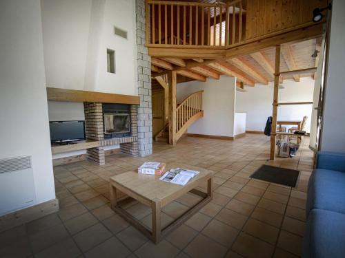 a living room with a table and a fireplace at Village de Gites le Colombier in Mende