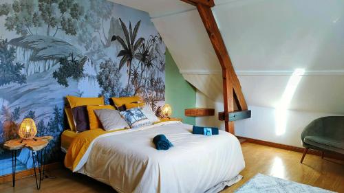 - une chambre avec un grand lit orné d'une peinture murale dans l'établissement La villa du lac d'orient, à Géraudot