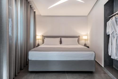 a bedroom with a large bed with two lamps at Santa Irina Luxury Sunny Lofts in Perivolos